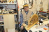 Werner Diebenow sitzt in seiner Werkstatt im Keller. Auf dem Arbeitstisch steht ein Schwibbogen, der repariert werden muss.