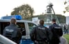 Polizeibeamte stehen vor der Kali-Grube in Unterbreizbach (Thüringen). Dort sind nach einem Gasausbruch mehrere Bergleute eingeschlossen worden.
