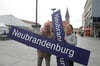 Nordkurier-Reporter Susanne Schulz und Thomas Beigang zeigen die blauen Bahnhofsschilder, die jetzt versteigert werden.