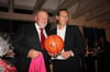 Walter Bleimann (links) vom Mercedes-Autohaus BrinkmannBleimann  in Waren hat den prominenten Basketball inklusive T-Shirt ersteigert und nimmt beides aus den Händen von Andreas Dittmer in Besitz.