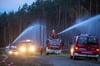 Feuerwehrleute löschen in der Nähe der evakuierten Ortschaft Alt Jabel einen großflächigen Waldbrand.