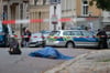 Ein Toter liegt nach den Schüssen in Halle auf der Straße, wurde von den Beamten abgedeckt.