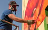 Mario Schuster malt Mohnblumen an die Hoffassade.