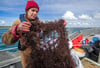 Meeresbiologin Gabriele Dederer hält an Bord eines Fischkutters ein von Tauchern gesichertes Geisternetz aus der Ostsee.