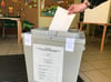 Eine Wählerin steckt im Wahllokal in der Eggesiner Grundschule ihren Stimmzettel in die Urne.