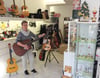 Waltraud Eberbach stimmt die Saiten einer Gitarre in den neuen Ladenräumen ihrer „Musikmuschel“. Die Musikalienhändlerin ist umgezogen.