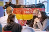 Beim Milchbauerntag des Bundesverbandes Deutscher Milchviehhalter (BDM) verfolgen die Teilnehmer die Reden, im Hintergrund steht eine schwarz-rot-goldene Plastikkuh mit der Aufschrift „Die faire Milch”.