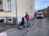 Mitarbeiter der Johanniter helfen dabei, Gehbehinderte aus dem Sperrkreis zu evakuieren.