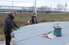 Dachdeckermeister Marcel Pagel (links) aus Brohm und sein Mitarbeiter Tobias Marquardt verschweißen Dachbahnen auf für das Dach des Salzsilos.