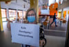 Freitag beginnen die Abi-Prüfungen: Oberstufenkoordinatorin Maren Wende klebt ein Hinweisschild an eine Glastür vor dem Prüfungsraum im Eldenburg-Gymnasium in Lübz (Landkreis Ludwigslust-Parchim).