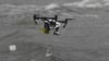 Mit etwa 65 Kilometer je Stunde fliegt die Drohne über die Ostsee zum Verunglückten und lässt eine Schwimmhilfe neben der Opfer ins Wasser plumpsen.