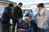 Der siebenjährige Magomed darf am Auto schon mal gucken, was Kilian Schneider (2.v.l.) von der Caritas für die Familie von Ruslan Musitov (links) mitgebracht hat.