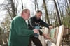 Forstamtsleiter Ralf Hecker (rechts) und Horst Schütze bringen die Tafeln an, die über die unsichtbaren Turopolje-Schweine informieren.