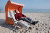 Einfach nur entspannt die Sonne genießen: Jan Müller, Geschäftsführer der Strandkorbfabrik Heringsdorf, zeigt am Strand auf der Insel Usedo einen faltbaren Strandkorb.