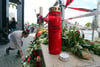 Am abgesperrten Zugang zur U-Bahnstation Olympia-Einkaufszentrum legen Menschen Blumen nieder, um der neun Opfer zu gedenken.