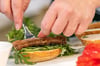 Hier wird ein veganer Fischersatz auf ein Burger-Brötchen gelegt. Wie gut sind Gastronomen in der Uckermark auf den Wunsch nach alternativen Gerichten vorbereitet?