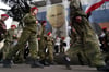 Uniformierte Jugendliche marschieren in Jalta anlässlich einer Aktion zum neunten Jahrestag der Krim-Annexion an einem Bild des russischen Präsidenten Wladimir Putin vorbei.