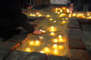 Menschen zünden Kerzen anlässlich des Gedenkgottesdienstes für die Opfer des Amoklaufs bei den Zeugen Jehovas in Hamburg an.