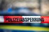 Ein Absperrband mit der Aufschrift «Polizeiabsperrung» ist vor einem Polizeiwagen aufgespannt.