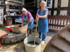 Karin Collin und Ingrid Siebert (r.) zeigen, wie aufwendig es früher war, die Wäsche zu waschen.