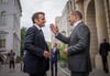 Bundeskanzler Olaf Scholz (SPD, r) begrüßt Emmanuel Macron, Präsident von Frankreich, vor einem gemeinsamen Abendessen zum Restaurant „Kochzimmer“ in Potsdam.