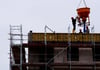 Arbeiter stehen auf einer Baustelle eines Wohngebäudes.