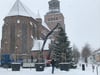 Bei Schneetreiben haben Mitarbeiter des Stadtbauhofes eine rund 9 Meter große Fichte auf dem Marktplatz in Malchin aufgestellt. 