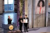 Ali (r.) und Kiana Rahmani (M.) halten die Medaille und die Urkunde während der Verleihung des Friedensnobelpreises 2023 im Rathaus von Oslo entgegen. Ali und Kiana nehmen den Friedensnobelpreis stellvertretend für ihre inhaftierte Mutter entgegen.