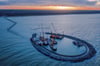 Mit Kranen und Baggern wird auf der Baustelle des zukünftigen Inselhafens in der Ostsee gearbeitet.
