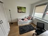 Ein anderes Zimmer u.a. mit Bett, Stuhl, Schrank, Lampe, Tisch und Sichtschutz&nbsp;