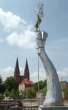 Die Kirchtürme der Pfarrkirche St. Marien im Hintergrund bilden einen optischen Kontrast zur Skulptur des „Parzival am See“ an der Seepromenade.